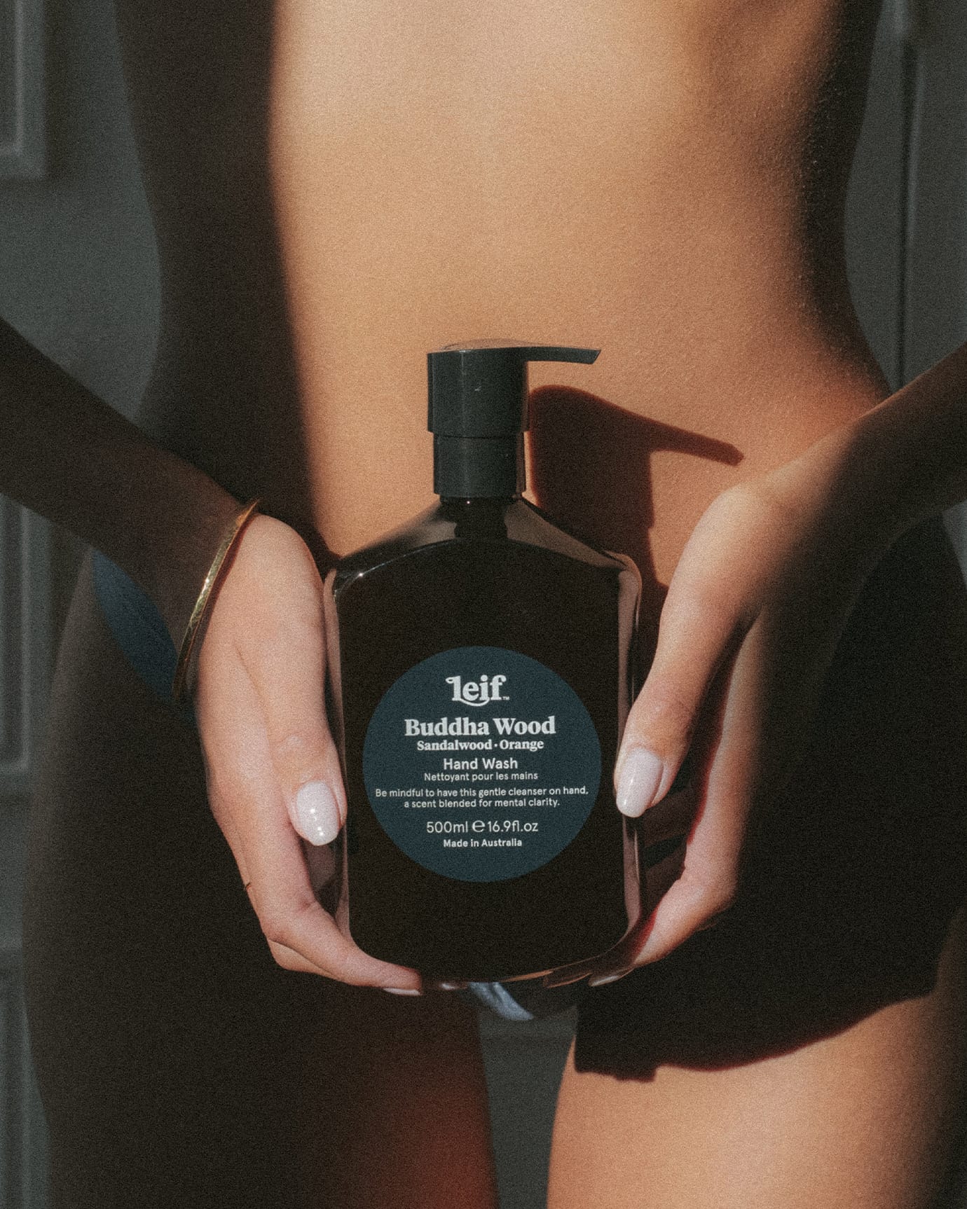 Leif Buddha Wood Hand Wash. Being held in front of a women's torso