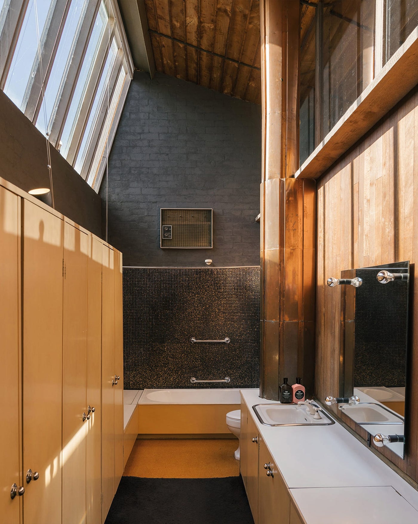 A bathroom within the Robin Boyd and the Walsh Street house, featuring copper, wooden and tiled details as well as Leif Buddha Wood Hand Wash and Hand Balm.