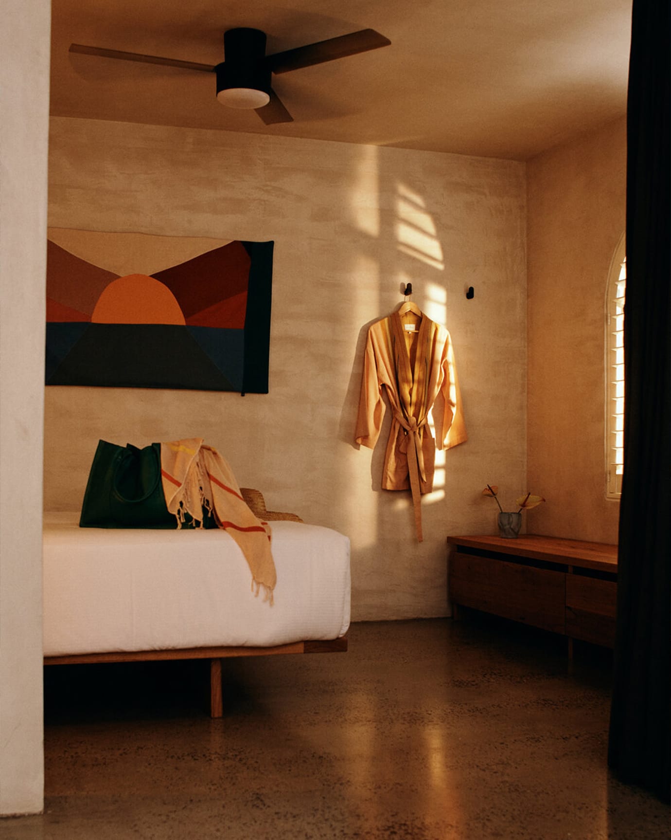 A bedroom at The Sunseeker, Byron Bay, featuring a bed, robe, bag and towel