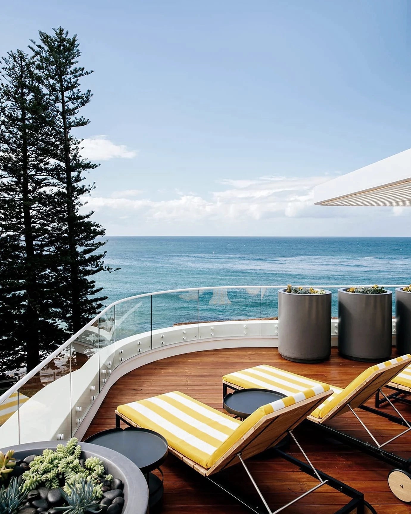 The seaside view from The Surf Yamba balcony, featuring pot-plants and deckchairs